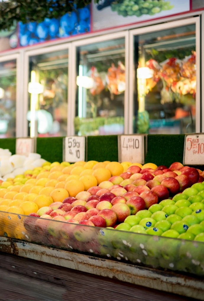 a man and a woman standing in front of a fruit stand